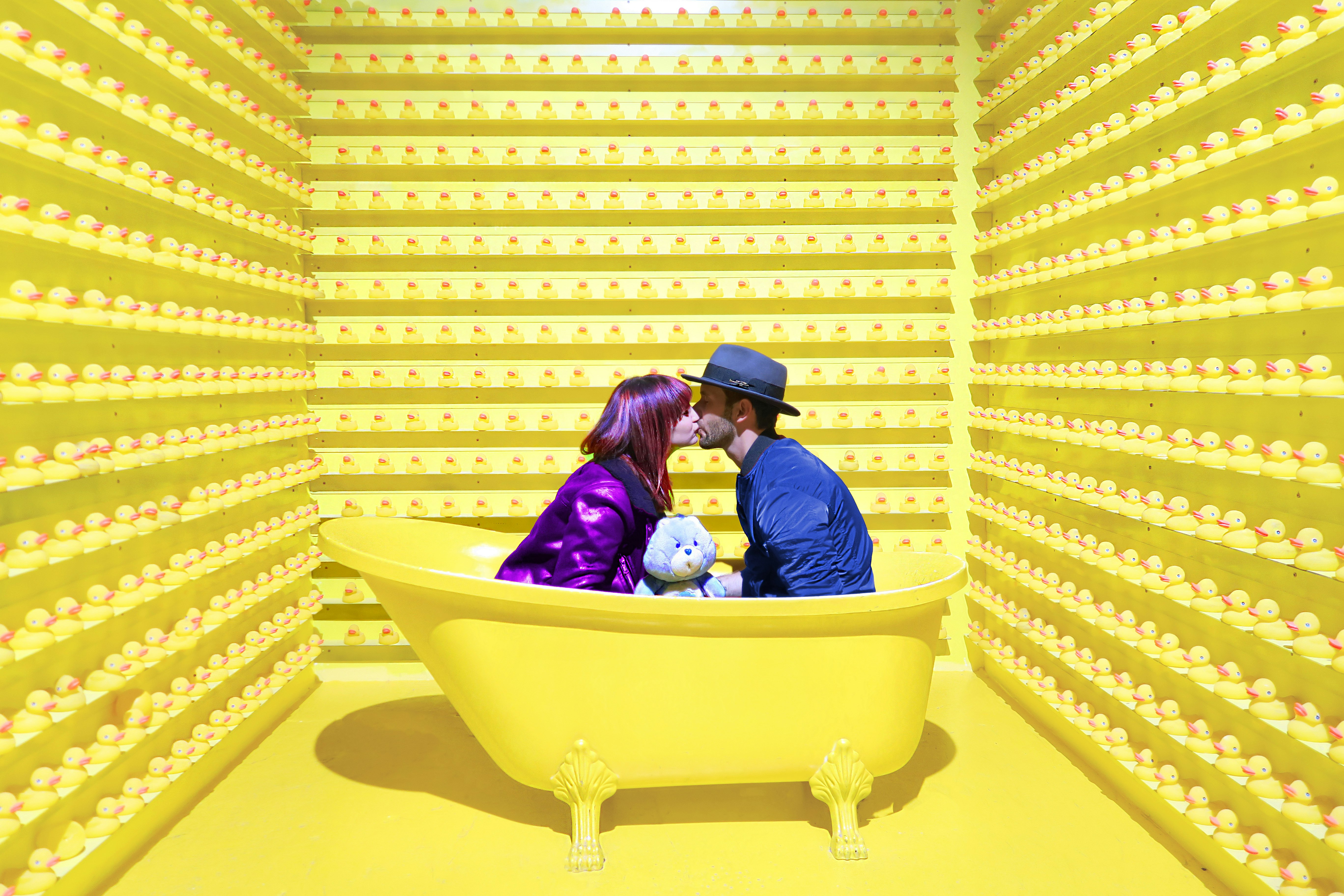 man and woman kissing inside yellow bathtub